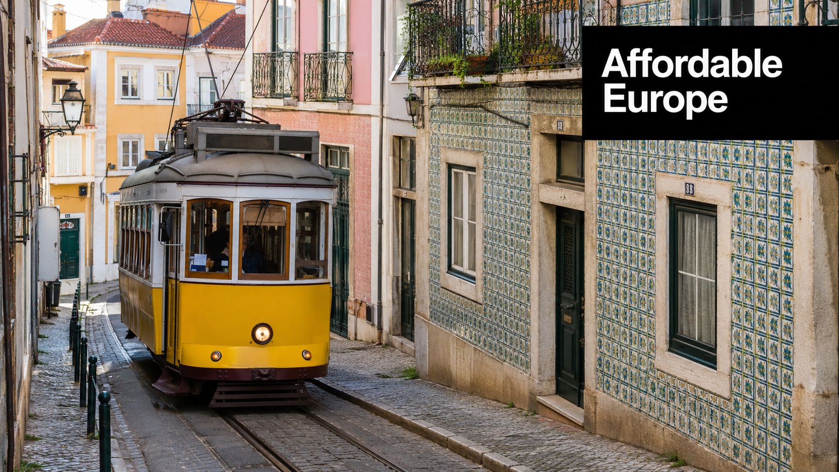 A iconic yellow tram traveling through a narrow cobblestone street in Lisbon, Portugal, on a sunny day.